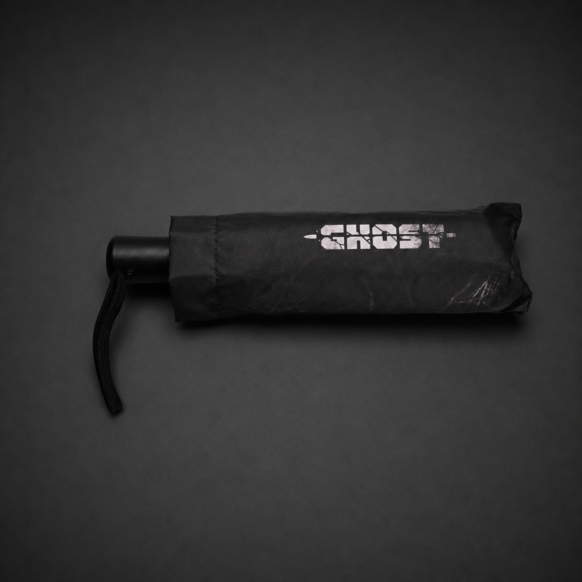Folded automatic umbrella in its black printed storage sleeve with wrist strap